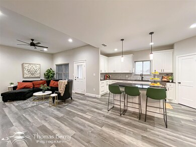 Kitchen featuring white cabinetry, light hardwood 