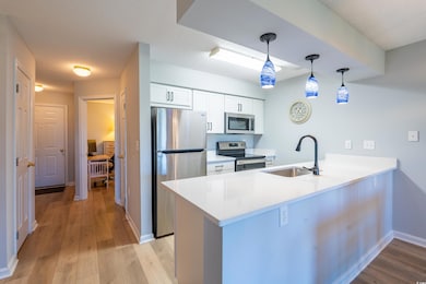 Kitchen with a peninsula, baseboards, light wood-s