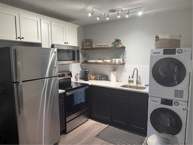 Kitchen featuring fridge, stove, a sink, stacked w