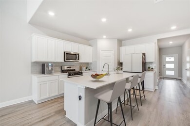 Kitchen featuring white cabinets, appliances with