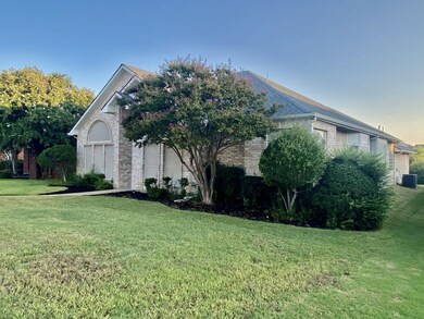 Obstructed view of property featuring brick siding, a front lawn, and a garage