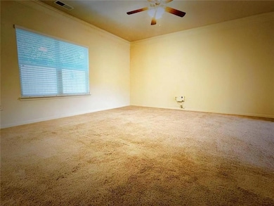 Carpeted empty room with crown molding and ceiling fan