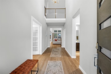 Entryway with a towering ceiling and light wood-style flooring