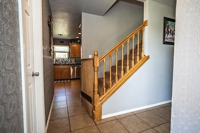 Staircase with baseboards, a textured ceiling, and