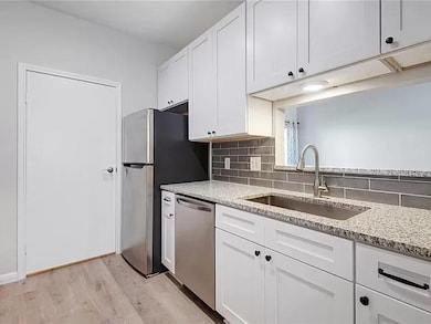 Kitchen featuring tasteful backsplash, light wood