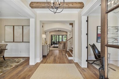 Step through the grand entryway and experience an inviting ambiance defined by soaring 10-foot ceilings, wide-plank hardwood floors, and meticulous architectural detailing