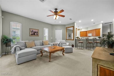 Carpeted living room featuring ceiling fan