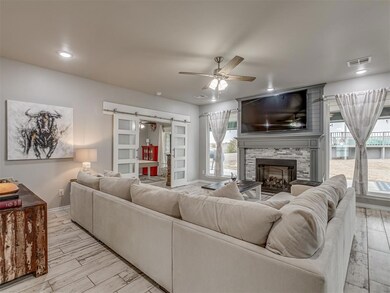 Living room featuring a stone fireplace, a barn do