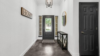 Foyer entrance featuring an inviting chandelier and ornamental molding
