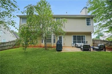 Rear view of property with a fenced backyard, a patio area, a chimney, and an outdoor hangout area