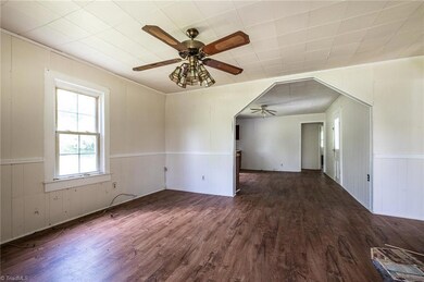 Farm house has an open layout with the living room opening into the kitchen with laminate faux wood flooring.