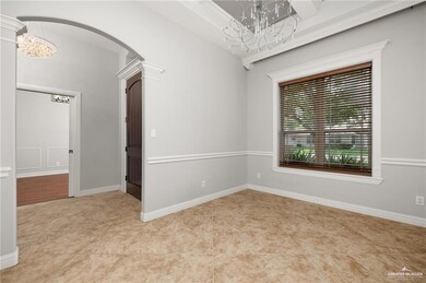 Spare room with arched walkways, a notable chandelier, and tile patterned floors