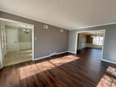Empty room with dark wood-style flooring, visible 