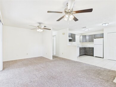 Unfurnished living room with light colored carpet, light tile patterned floors, and ceiling fan
