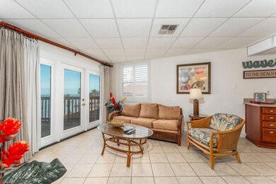 Living room with light tile patterned floors, visible vents, and a paneled ceiling