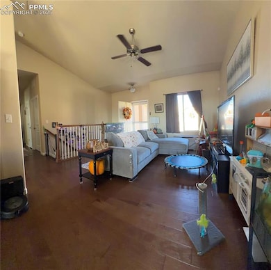 Living room with dark wood-type flooring, ceiling fan, and vaulted ceiling