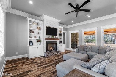 Living room featuring ornamental molding, a brick 