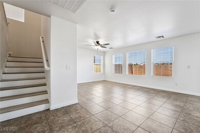 Tiled spare room featuring stairway, a ceiling fan