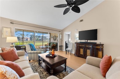 Living area with baseboards, visible vents, a ceiling fan, wood finished floors, and high vaulted ceiling