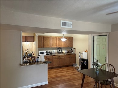 Kitchen with decorative backsplash, wood-type floo
