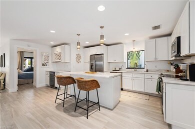 Kitchen featuring white cabinets, wine cooler, a k