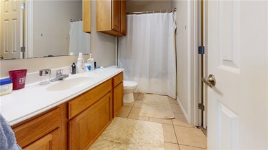 Full bath with vanity, toilet, tile patterned floo