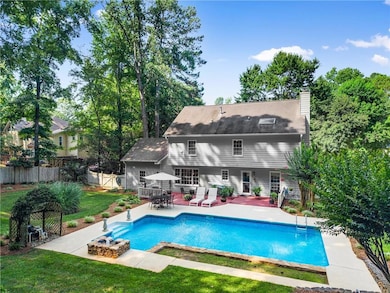 Rear view of property featuring a patio, an outdoor pool, a chimney, and a shingled roof