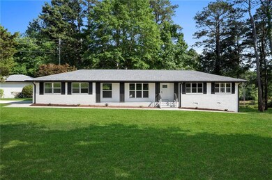 Ranch-style home with a front yard and brick sidin