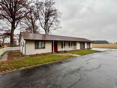 Single story home featuring a garage, covered porch, a metal roof, and driveway