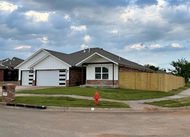 View of front of home with a garage, brick siding, a shingled roof, asphalt driveway, and board and batten siding