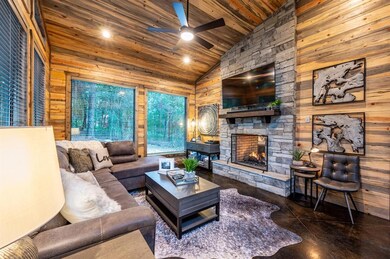 Living room with ceiling fan, a fireplace, wooden 