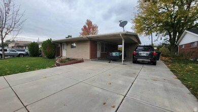 View of front of house with a front lawn, driveway, brick siding, and an attached carport
