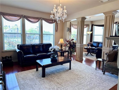 Living room with ornate columns, a healthy amount 