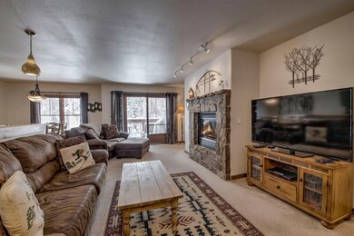 Living room featuring a stone fireplace, light col