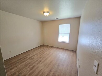 Spare room with wood finished floors, a textured c