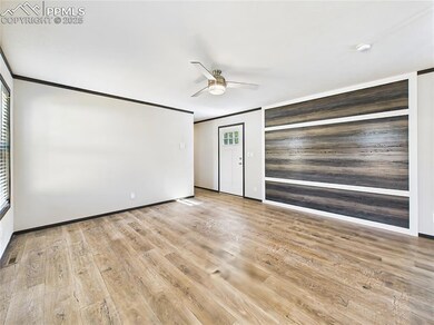 Living Room (Reverse View) – Features a bold accent wall with wood-style paneling and crisp white trim, adding modern contrast to the space.