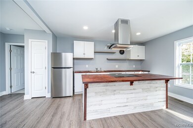 Kitchen featuring sink, island exhaust hood, stain