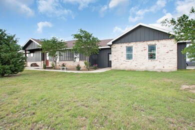 View of front of property with a front lawn, bric