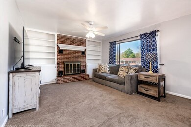 The brick fireplace flanked by bookshelves create
