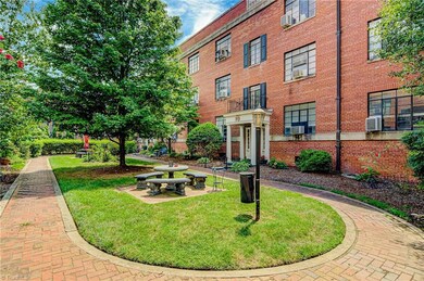 Courtyard features brick pathway throughout, seating areas, and mature trees and gorgeous landscaping.