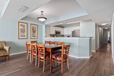 Dining room with dark wood-style flooring, baseboa