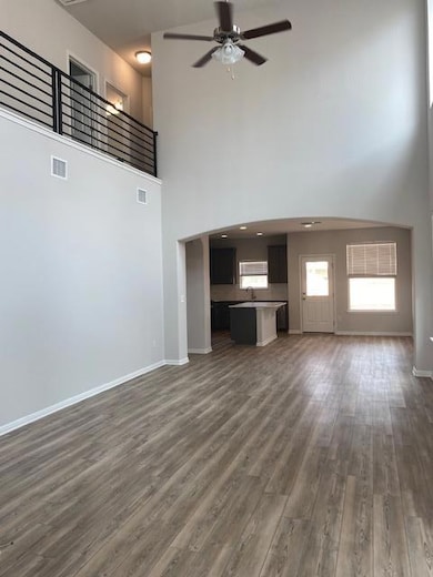 Unfurnished living room featuring a towering ceil