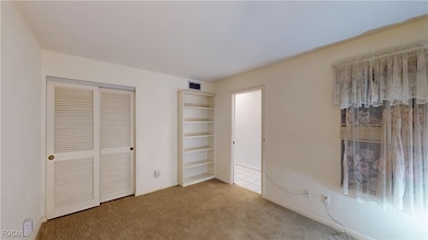 Unfurnished bedroom with carpet and a closet