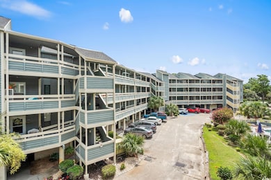 View of apartment building / complex with uncovered parking