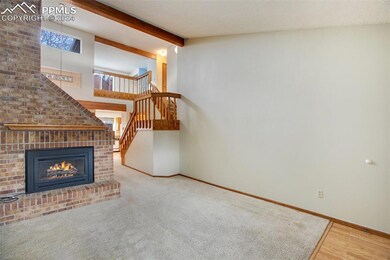 Living area to include brick fireplace and stairs 