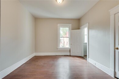 Unfurnished bedroom with wood finished floors and baseboards