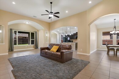 Living area with arched walkways, light tile patt