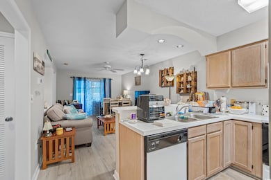 Kitchen featuring white dishwasher, light brown cabinets, open floor plan, a peninsula, and recessed lighting