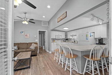 Kitchen featuring white appliances, ceiling fan, g