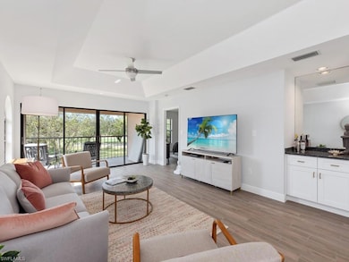 Living room with ceiling fan, a raised ceiling, an